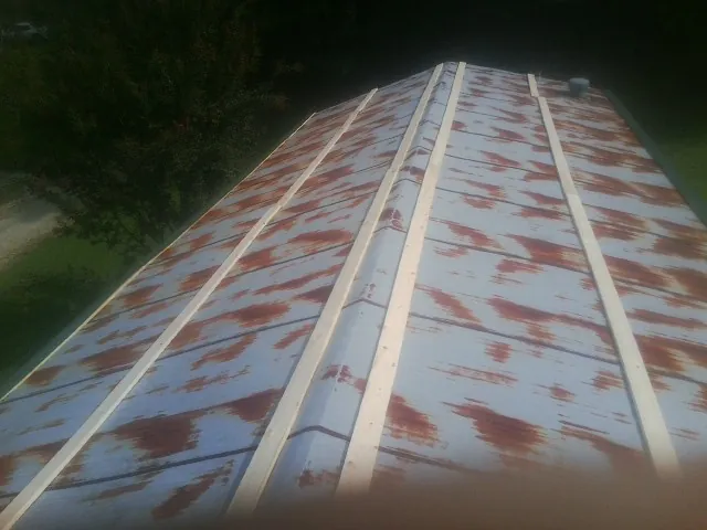 Rusted metal roof panels with new wood purlins before replacement — Storm Damage Roof Repair in Merritt Island by Roofing Brothers