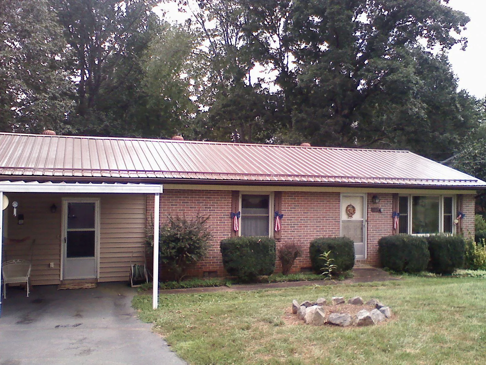 Bronze metal roof and carport on a brick ranch home — Roof Repair work by our crew in Merritt Island